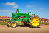 TRA 01 RK0178 01
John Deere Antique Tractor Green And Yellow Profile View On Dirt By Field Of Flowers