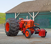 TRA 01 RK0192 01
1948 Case DC Tractor Orange 3/4 Front View On Pavement By Barn