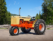 TRA 01 RK0197 01
1962 Case 530 Tractor Flambeau Red And Desert Sunset 3/4 Side View On Gravel By Trees