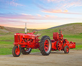 TRA 01 RK0208 01
1955 Farmall 300 Tractor Red And 1954 McCormick 55W 3/4 Side View On Dirt By Grassy Hills At Dusk
