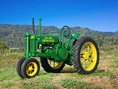 TRA 01 RK0233 01
1936 John Deere Model B Tractor Green And Yellow 3/4 Side View On Grass By Hills