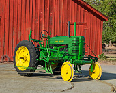 TRA 01 RK0237 01
1947 John Deere G Tractor Green And Yellow 3/4 Side View On Dirt By Red Barn