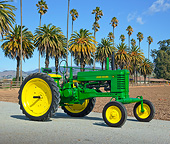 TRA 01 RK0241 01
1950 John Deere B Tractor Green And Yellow 3/4 Side View On Pavement By Palm Trees