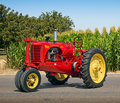 TRA 01 RK0248 01
1938 Massey-Harris Challenger Tractor Red And Yellow 3/4 Side View On Pavement By Cornfield