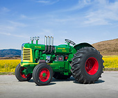 TRA 01 RK0271 01
1957 Oliver Super 99 Tractor Green, Yellow And Red 3/4 Side View On Pavement By Field Of Wildflowers