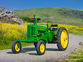 TRA 01 RK0278 01
1948 John Deere BW Tractor Green And Yellow 3/4 Front View On Pavement By Yellow Wildflowers
