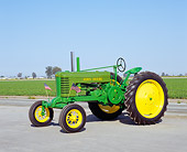 TRA 01 RK0066 04
1943 John Deere B-W Green And Yellow Tractor 3/4 Side View On Pavement Blue Sky