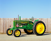 TRA 01 RK0067 04
1943 John Deere W-8 Green And Yellow Tractor 3/4 Side View By Fence