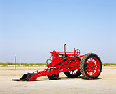 TRA 01 RK0085 01
1938 McCormick Deering Farmall F-12 Red Tractor 3/4 Front View On Dirt Blue Sky