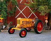 TRA 01 RK0108 02
1949 Minneapolis-Moline ZAE Gold Tractor 3/4 Front View On Gravel By Barn