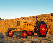 TRA 01 RK0109 03
1949 Minneapolis-Moline ZAE Gold Tractor 3/4 Front View By Hay Stacks At Dusk