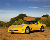 VET 01 RK0464 02
1981 Chevrolet Corvette Yellow Low 3/4 Front View On Dry Grass Trees And Hills