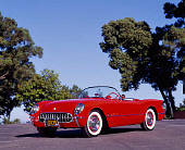 VET 02 RK0036 02
1955 Chevrolet Corvette Convertible Red Low 3/4 Front View On Pavement Trees Blue Sky