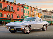 VET 03 BK0007 01
1964 Chevrolet Corvette Gray 3/4 Front View On Pavement By Colorful Buildings