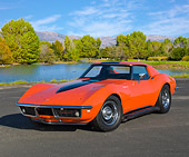 VET 03 RK0774 01
1968 Chevrolet Corvette Orange With Black Stripe 3/4 Front View On Pavement By Pond And Trees
