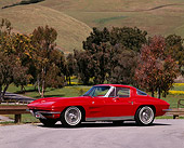VET 03 RK0063 08
1963 Chevrolet Corvette Split Window 327 Red 3/4 Front View On Pavement By Grass Hills And Trees