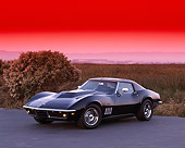 VET 03 RK0203 01
1969 Chevrolet Corvette Stingray Black 3/4 Front View On Pavement By Tall Grass Red Sky