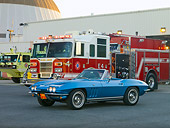 VET 03 RK0594 01
1965 Chevrolet Corvette Convertible Nassau Blue 3/4 Front View On Pavement By Fire Trucks