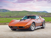 VET 05 RK0224 01
1974 Chevrolet Corvette Sunburst Yellow 3/4 Front View On Gravel By Grass Field And Hills