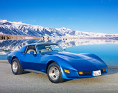 VET 05 RK0228 01
1975 Chevrolet Corvette Blue 3/4 Front View On Pavement By Snowy Peaks And Water