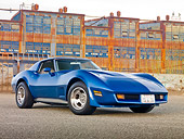 VET 05 RK0230 01
1975 Chevrolet Corvette Blue 3/4 Front View On Pavement By Old Factory Buildings