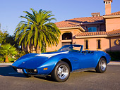 VET 05 RK0153 01
1974 Chevrolet Corvette Convertible Blue 3/4 Front View On Pavement By Palm Tree Building Blue Sky