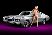 WMN 03 RK0307 01
1968 Oldsmobile Hurst/Olds Silver With Black Stripes 3/4 Front View In Studio With Swimsuit Model