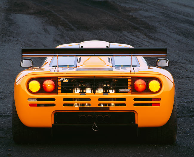 McLaren F1 LM Orange Rear View Lights On In Field | Kimballstock